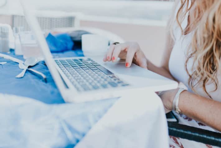 Woman browsing on a white laptop