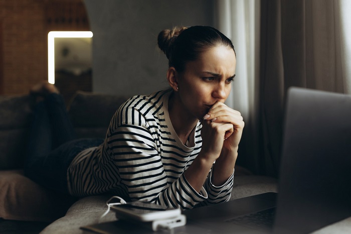 A woman using a laptop. Practising cyber hygiene can help safeguard against clickjacking attacks