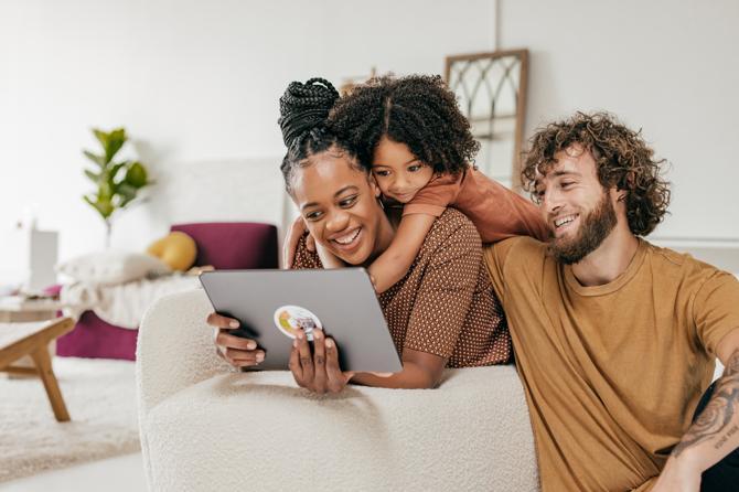 A woman researching online safety tips with her child and partner.